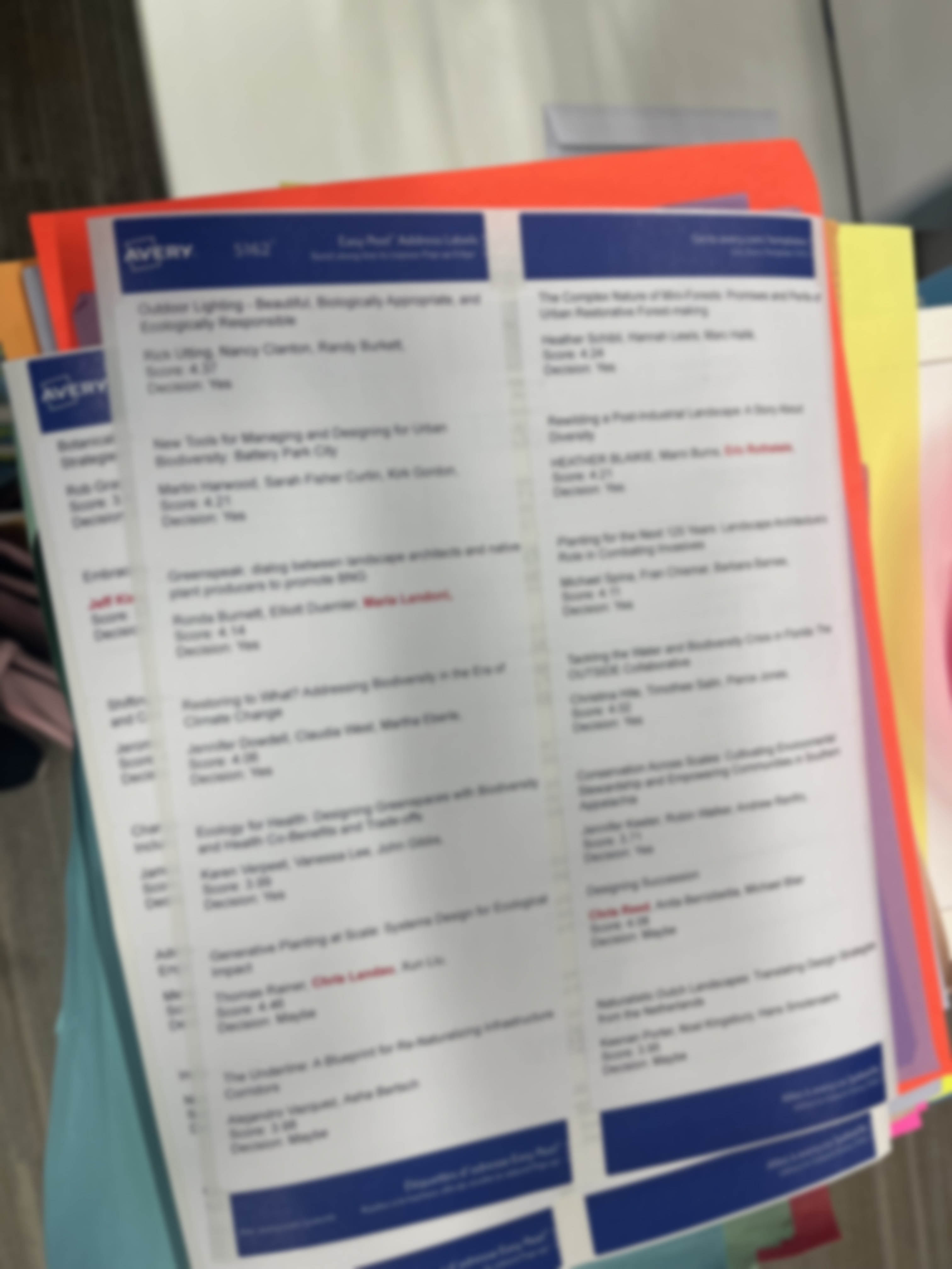 Mail-merged session labels printed on colored paper by track, ready to be cut and sorted